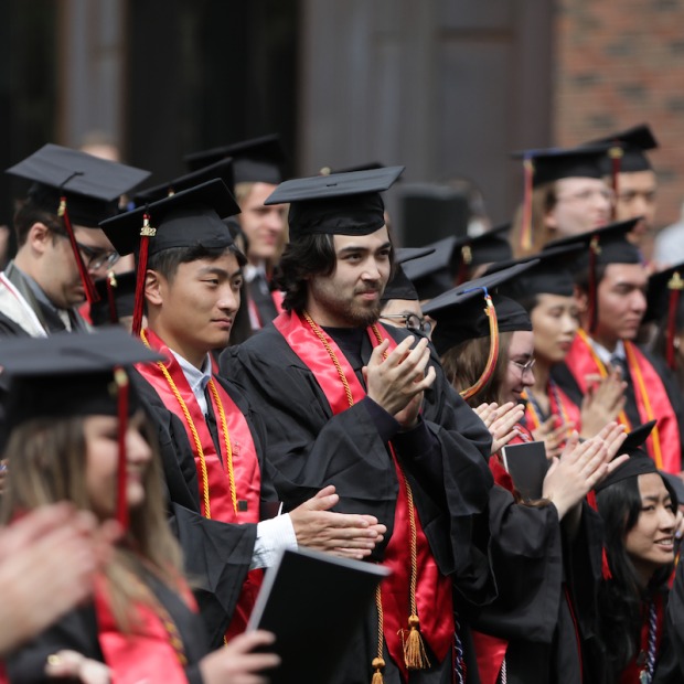 Seniors in full academic regalia applaud at 2022 Commencent ceremony