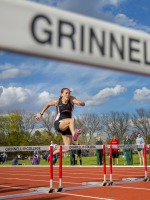 Student jumping hurdles on the outdoor track.