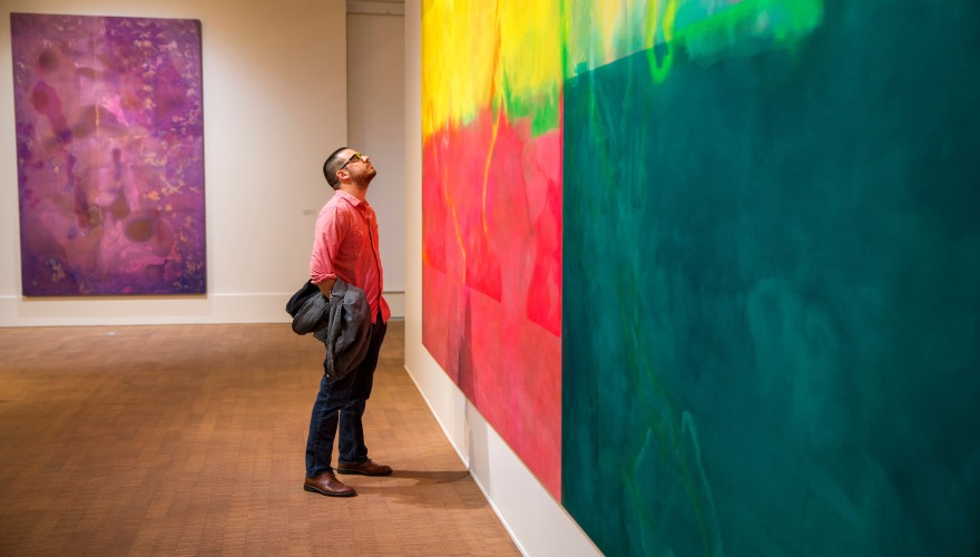 museum guest peering up at a painting