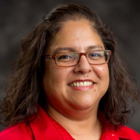 A woman smiles for a headshot