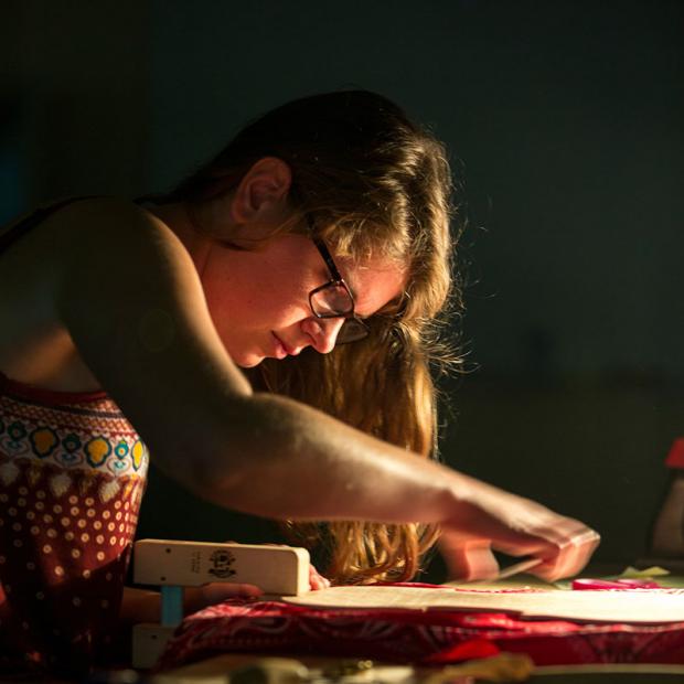 student sands part of a violin she's making