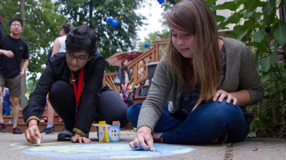 Students drawing with sidewalk chalk