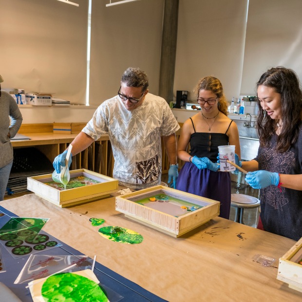 Haitian artist Edouard Duval-Carrié works with students while teaching a short course in which students create resin blocks