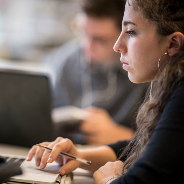 Young woman working on a laptop at the library