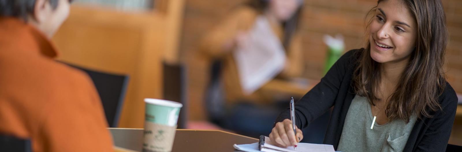 Students sits at table in Spencer Grille