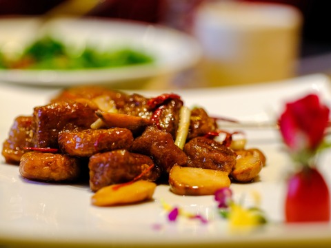 stir-fried beef on a plate at a restaurant