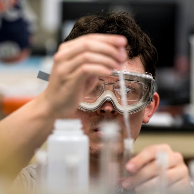 Student with beaker and pipette