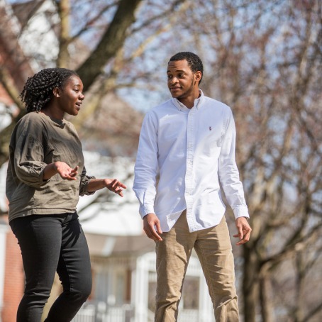 CLS adviser and student walk side by side. Student talks passionately to the adviser.