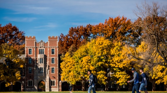 students walking on campus in front of Gates Tower