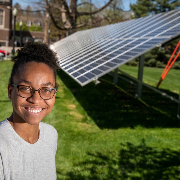 Avery Barnett in front of solar panels