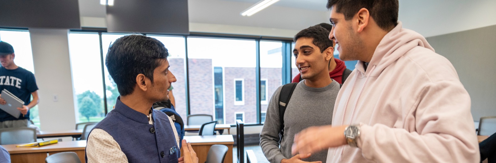 Grinnell Prize winner talking with 2 students 