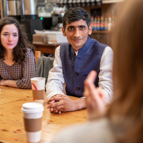 man at coffee shop with students