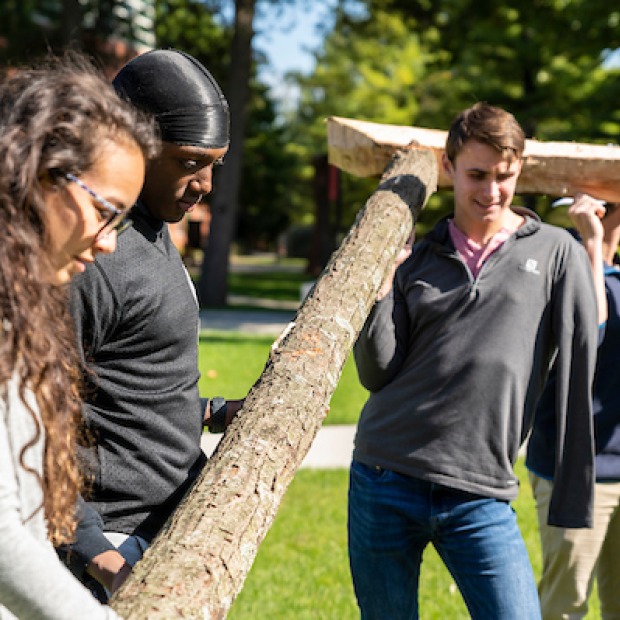 Students raise wooden arch