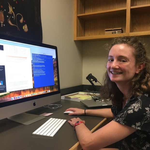 Lauren Frankel in front of computer monitor looking at camera.