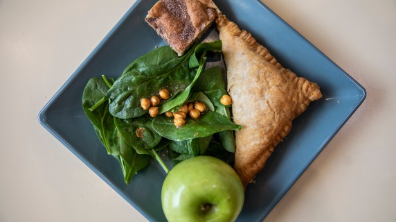 Marnie's lunch a spinach salad, a turnover, a green apple, and a dessert bar