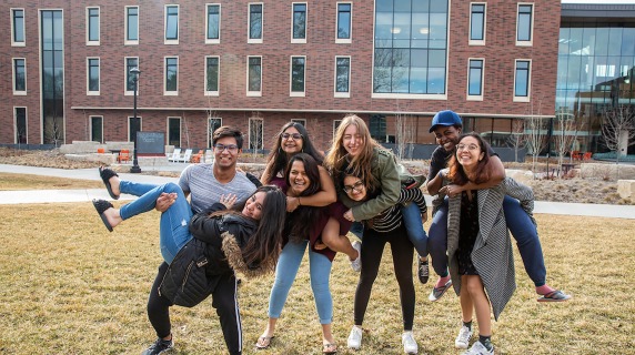 Group of students holds up another student