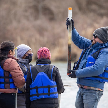 Students and professor examine water sample