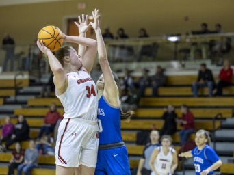 Sara shoots the basketball while an opposing player plays defense