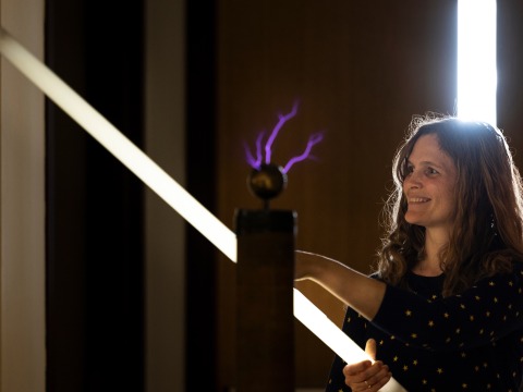 Professor Charlote Christensen in class with electrical current visible in the foreground during and experiment