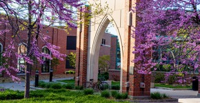 SO stand alone stone and brick archway with blooming red bud trees
