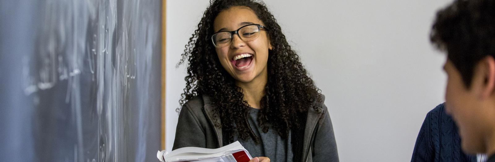 student laughs at blackboard