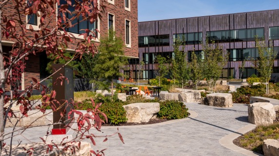 Landscaping in front of HSSC including curving sidewalks, plantings, boulder seating and signage 