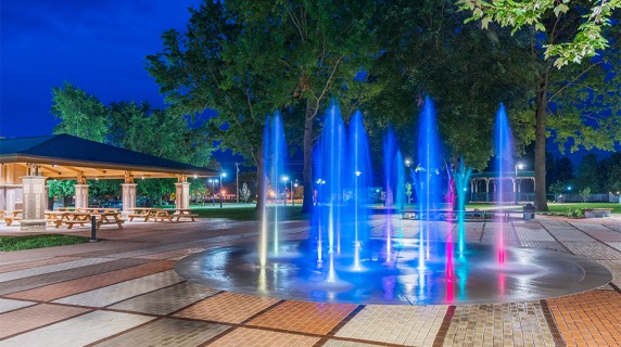 Central Park splash pad at night with reflecting lights