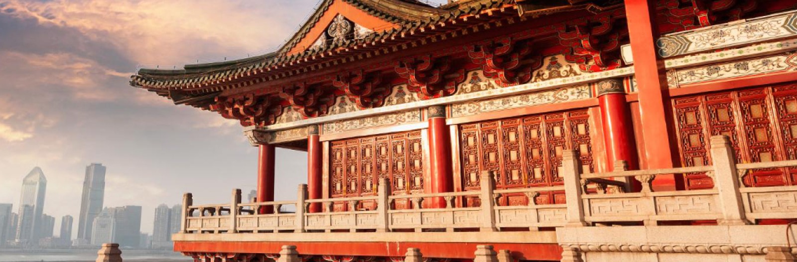 A traditional red Chinese building in foreground and skyscrapers in background