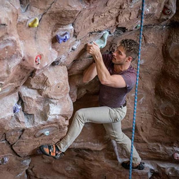 A student escalates the climbing wall