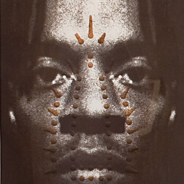 Portrait of artist Willie Cole, with the markings of the holes of a clothing iron superimposed on his face.