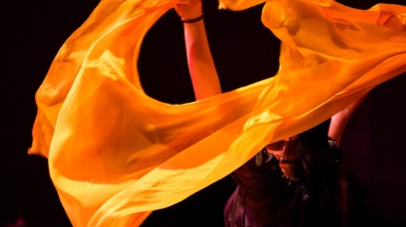 Student dances with bright orange scarf