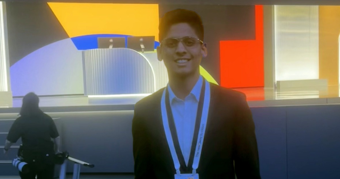 Deepit Chandgothia '24 at night in front of the bright, colorful lights of the convention center.