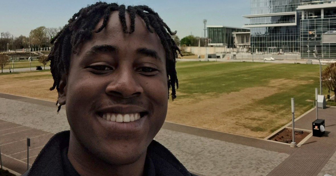 Dennis outside in Atlanta on a clear, blue day. 