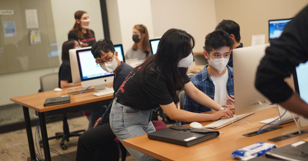 A student helping another student at a computer