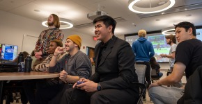 Prommolmard and other students hold controllers in a classroom, playing video games.
