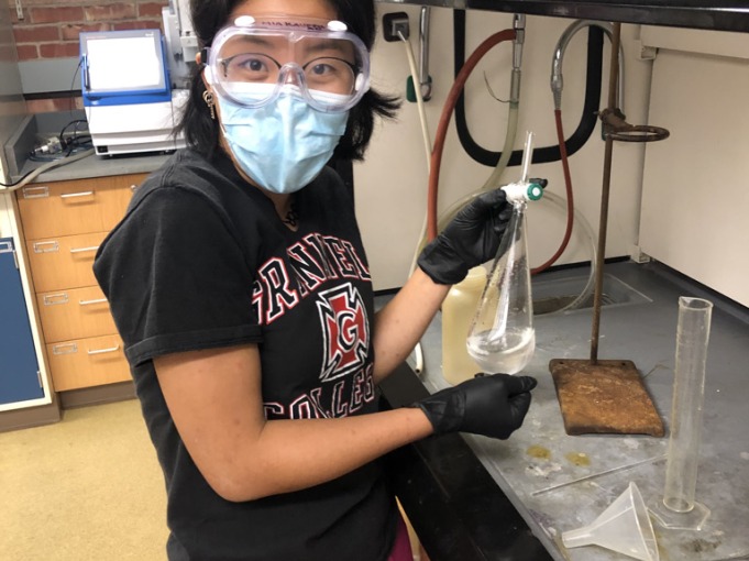 Mia proudly holds a flask with tubes in her hands.