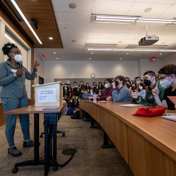 A woman faculty member speaks to a full classroom at a teach-in on the war in Ukraine