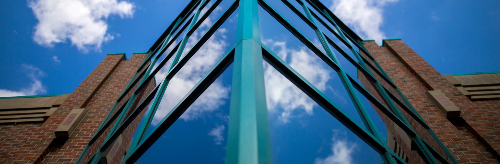 picture of windows and brick building with blue sky and clouds