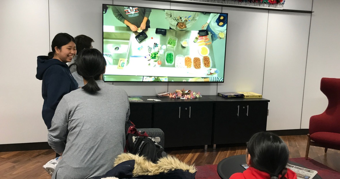 Students at the Global Livingroom watching live feed from the Global Kitchen  
