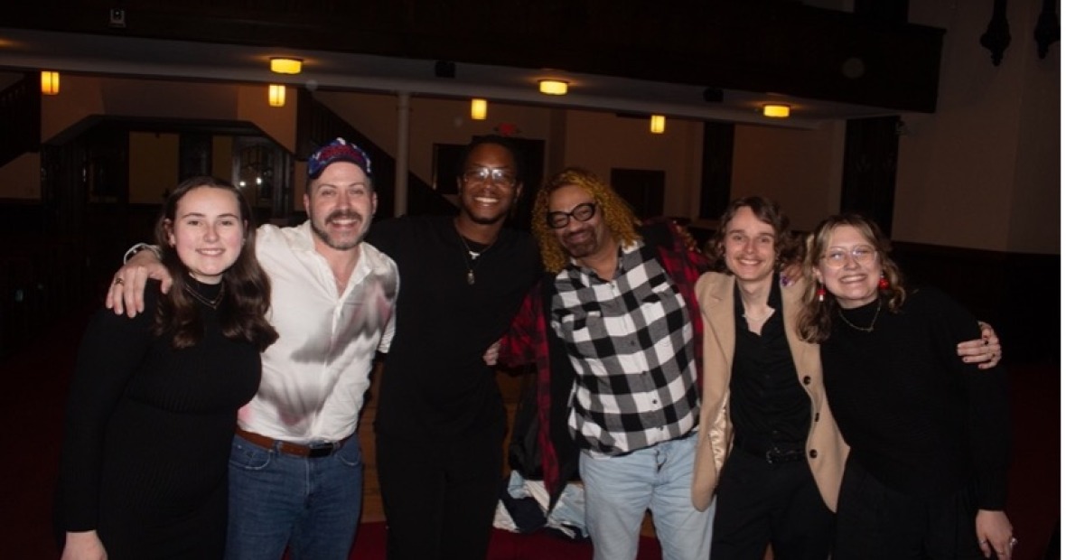 6 people pose arm in arm in a line