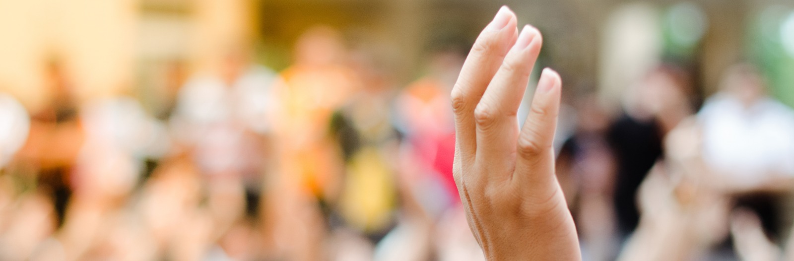 Hand raised with crowd in background