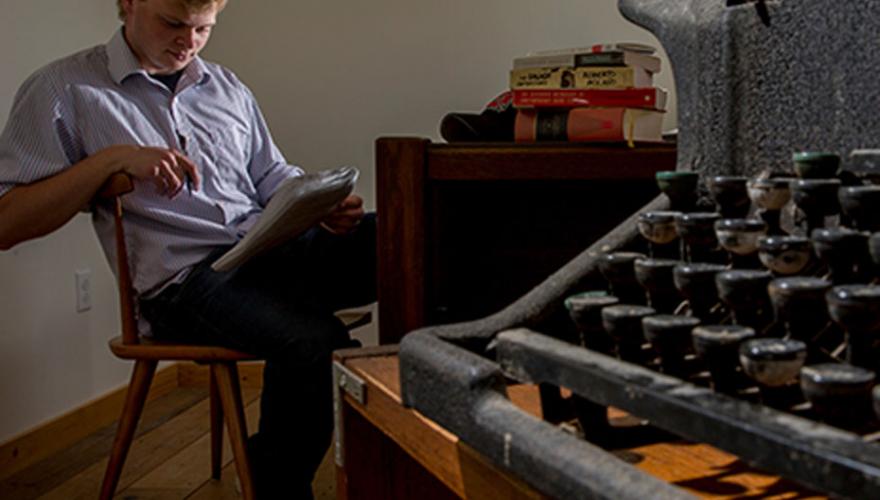 typewriter in foreground, someone writing in background