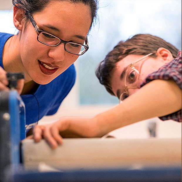Students adjust a clay slab roller