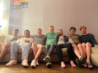 Swim and dive team smiling at picture relaxed on a couch