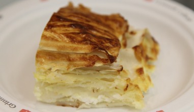 A square piece of banitsa, a flour pastry with cheese oozing from the inside.