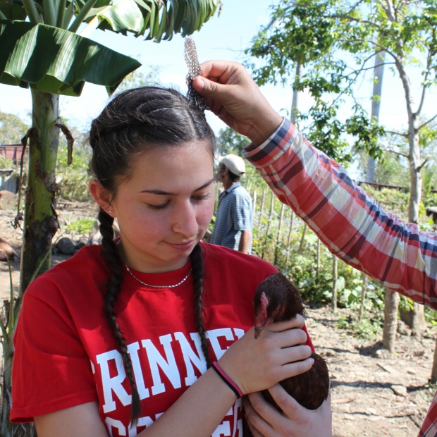 Student with chicken in small village in Cuba.