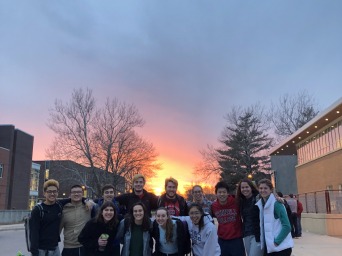 Me and my twelve friends gather together for pictures. We have a beautiful sunset behind us. 