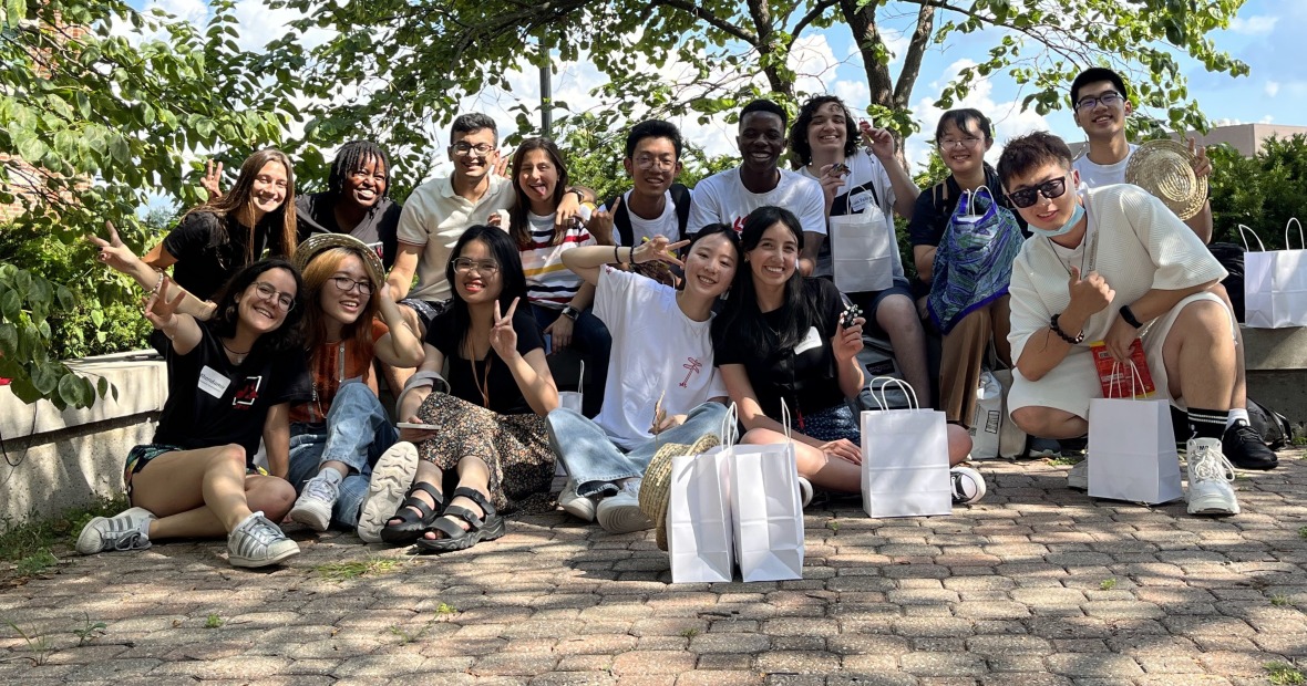 Several people sitting together, holding up little trinkets or posing for the camera