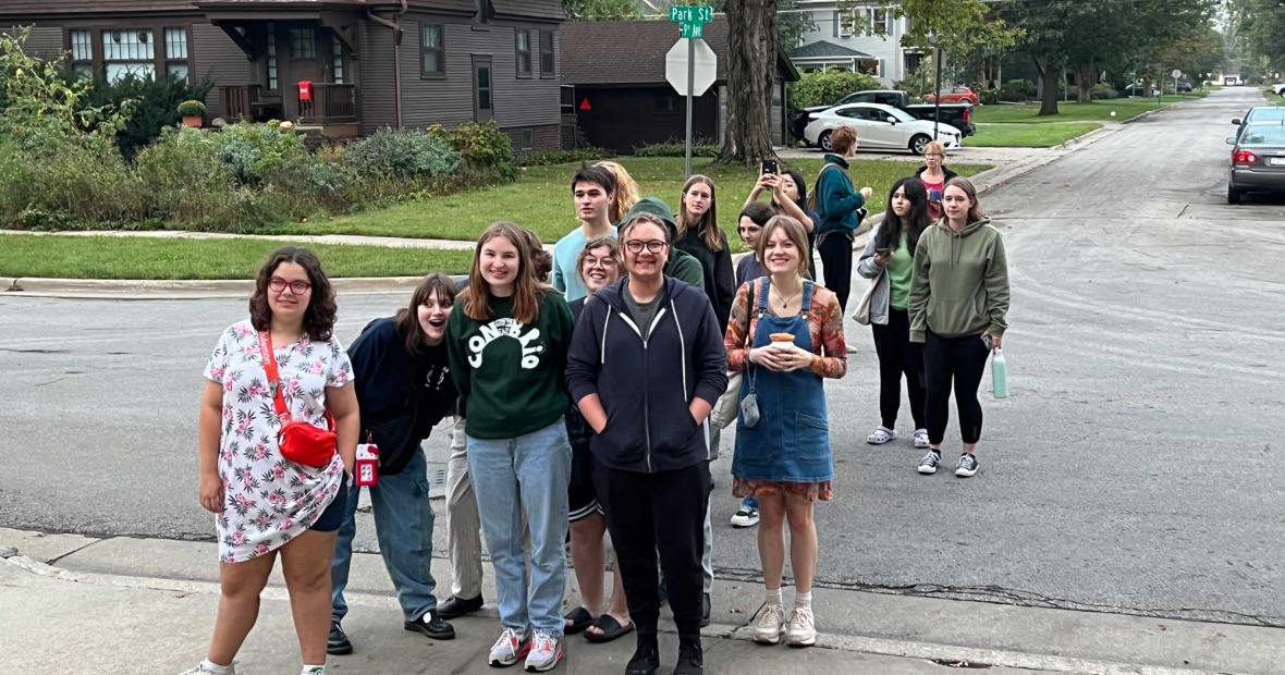 Mix of students stand together at a quiet street corner