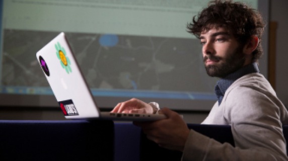Estudiante usando su computadora. Student using a laptop. 